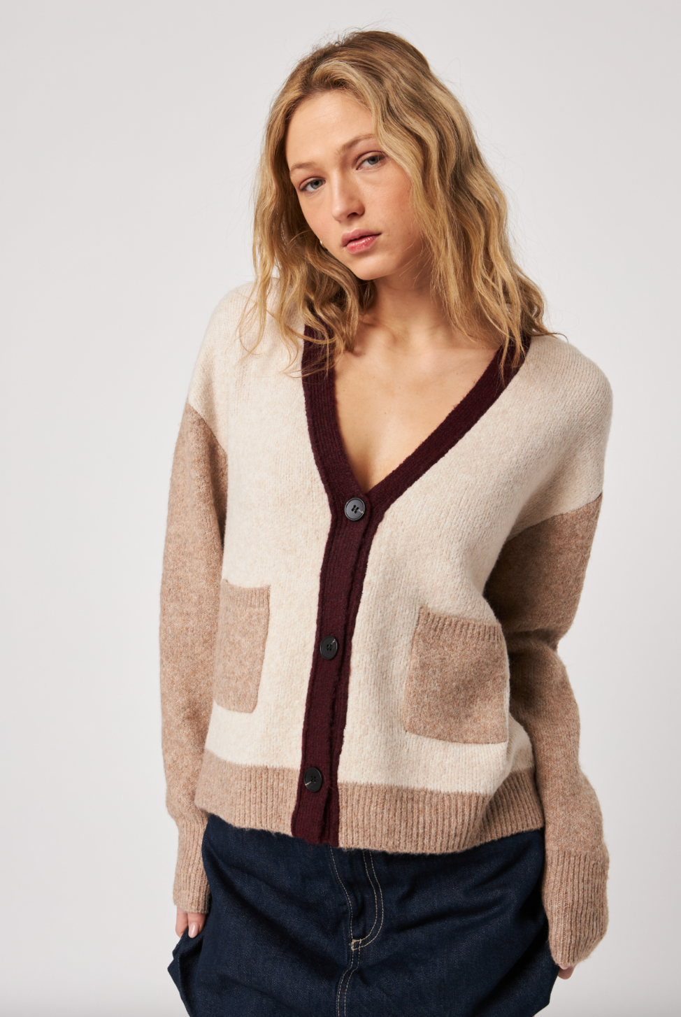 Woman wearing a patterned cardigan on a plain background