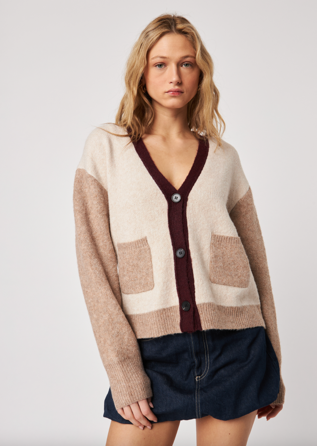 Woman wearing a patterned cardigan with a neutral background